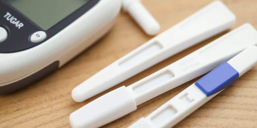 Photograph of blood sugar test instruments on a wooden table.